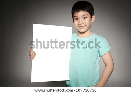 Portrait of Happy Asian boy with blank plate for add your text on gray background