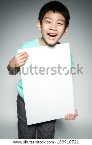 Portrait of Asian happy child with blank plate for add your text on gray background