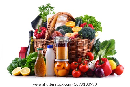 Wicker basket with assorted grocery products including fresh vegetables and fruits Royalty-Free Stock Photo #1899133990