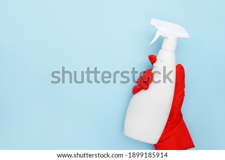 Cleaning Service Worker hand with white bottle on blue background with copy space