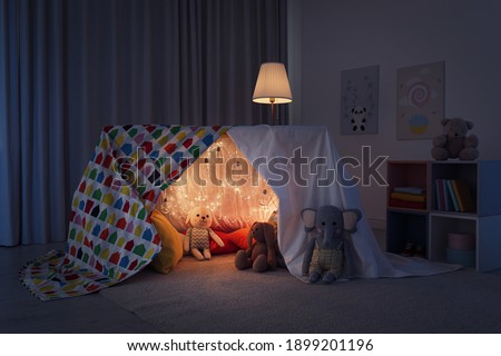 Play tent decorated with festive lights in modern child's room Royalty-Free Stock Photo #1899201196