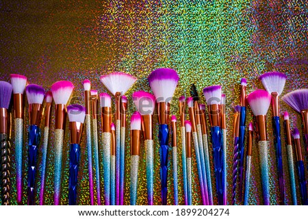 Cosmetic Professional Makeup Brushes on metallic glitter background, closeup, text place