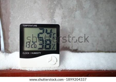 The humidity indicator is indicated on a hygrometer installed on the snow. Picture of an electronic device for testing air temperature and humidity
