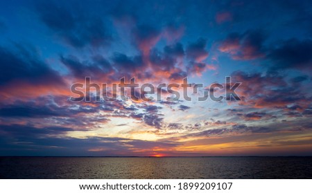 view of the north carolina outer banks sound at sunset. water and sky are vivid and the water calm. taken in late summer.