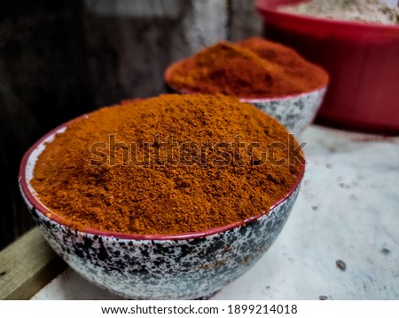 Pile of homemade Indian garam masala or curry powder in bowl on blur background.