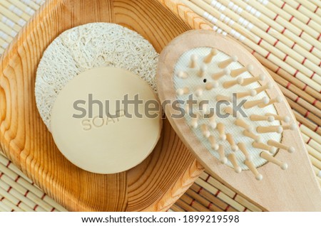 Bar of soap (solid shampoo) and wooden massage hair brush. Eco friendly toiletries. Natural beauty treatment, skin-care or zero waste concept. Top view, copy space.  Royalty-Free Stock Photo #1899219598