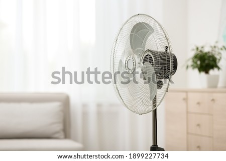 Modern electric fan in room. Space for text Royalty-Free Stock Photo #1899227734