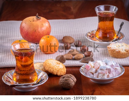 Glasses of tea and the Turkish delight on a table with fruits nuts and cookies