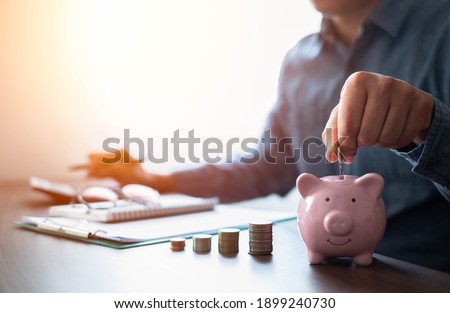 Shot of man hand putting coins in pink piggy bank with money stack step up growing growth. Planning step up, saving money for future plan, retirement fund. Business investment-finance account concept.