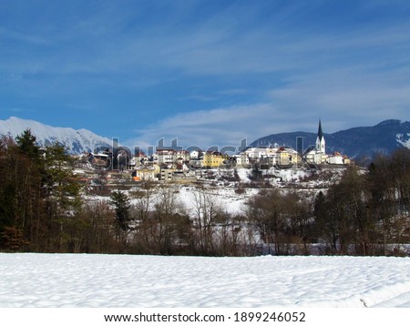 View of the historical town of Radovljica in Gorenjska, Slovenia in winter with mountains covered in snow in Karawanks mountain range behind and a field in front Royalty-Free Stock Photo #1899246052