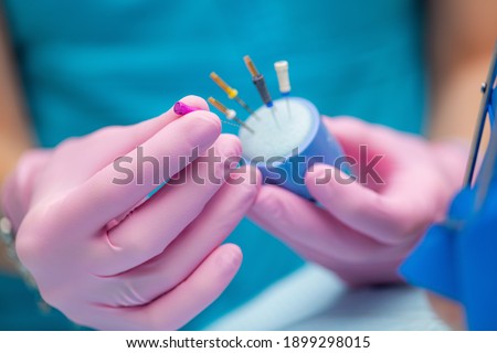 An Endodontist Preparing Barbed Broach for Endodontic Treatment in Dental Clinic. Royalty-Free Stock Photo #1899298015