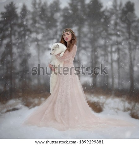 Art photo of a girl in a cream dress with a polar fox in her hands
