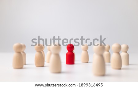 A wooden figure standing with a team to influence and empowerment. Concept of leadership, successful competition winner and Leader with influence and Social distancing for a new normal lifestyle Royalty-Free Stock Photo #1899316495
