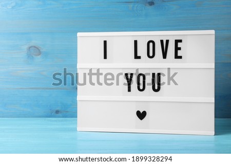 Lightbox with phrase I Love You on blue wooden table