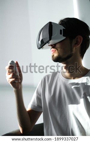 a young man plays a virtual game in VR glasses. home leisure on self-isolation at home. The virtual reality. portrait of handsome young man wearing virtual reality glasses