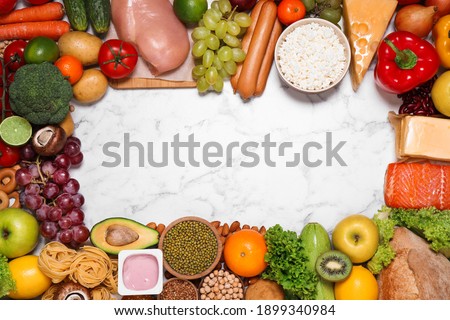 Frame of different products on white marble table, top view with space for text. Healthy food and balanced diet