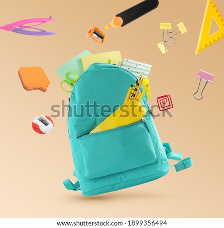 Backpack surrounded by flying school stationery on pale orange background Royalty-Free Stock Photo #1899356494