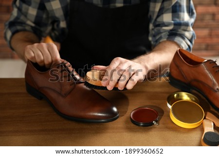 Master taking care of shoes in his workshop, closeup Royalty-Free Stock Photo #1899360652