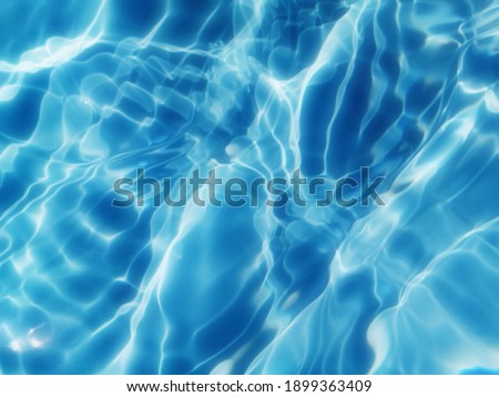 Closeup​ blur​ed​ abstract​ of​ surface​ blue​ water. Abstract​ of​ surface​ blue​ water​ reflected​ with​ sunlight​ for​ background. Blue​ sea. Blue​ water.​ Water​ splashed​ use​ for​ graphic​ desig Royalty-Free Stock Photo #1899363409