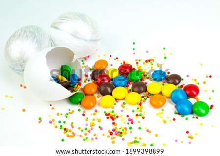 Happy Easter. Broken Easter egg with multi-colored candy decorations. on white background. Colorful eggs