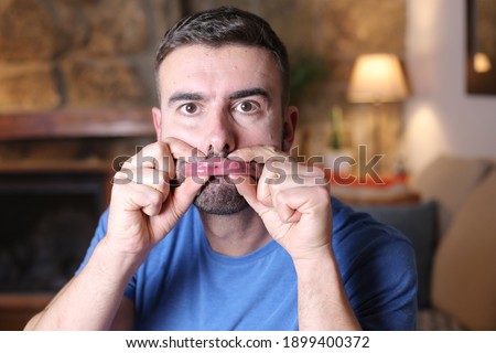 Man pressing lips with fingers