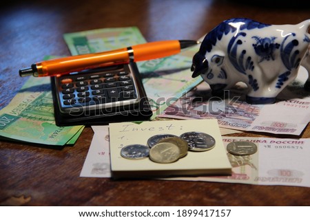 Cash notes, a pen with a notepad, and a calculator.