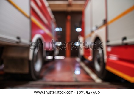 Blurred picture of fire trucks parked in fire brigade.