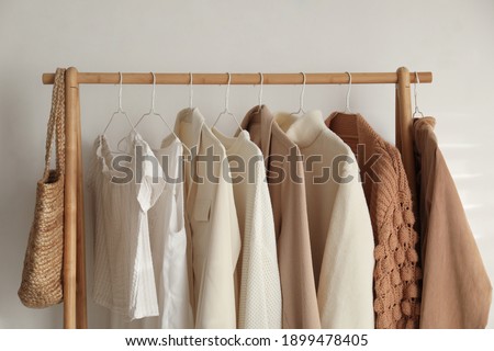 Rack with stylish women's clothes indoors. Modern interior design Royalty-Free Stock Photo #1899478405