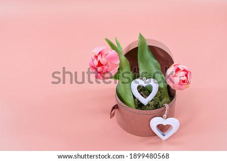 Valentine's Day flowers with hearts.Image with tulips on pink background for Valentine's Day, International Women's Day, birthday and declaration of love postcards, greeting cards and posters.