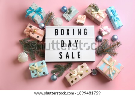 Lightbox with phrase BOXING DAY SALE and Christmas decorations on light pink background, flat lay