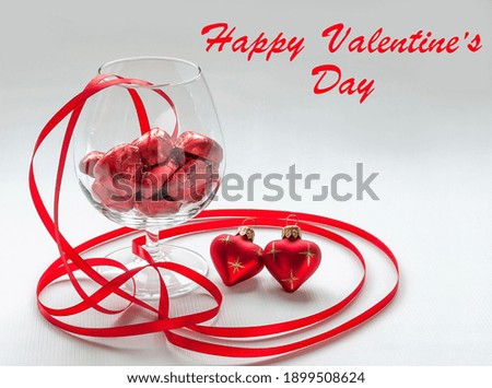 Ribbons and heart in red and a glass with sweets