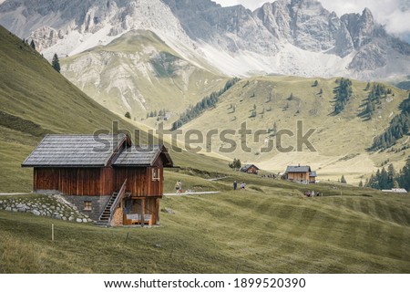 a wooden house with mountains in the background