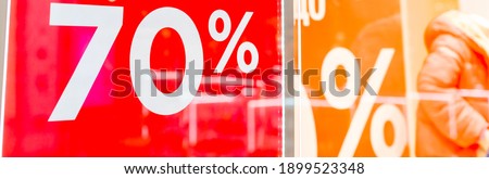 Sale up to 70 percent red sign. Red display with sale up to seventy percent inscription sticked on the store window.Seasonal discounts in stores, sale, Black Friday and shopping concept.
