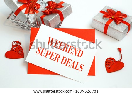 Shopping basket with gifts and text Weekend Super Deals on white paper note list. Holiday shopping concept.