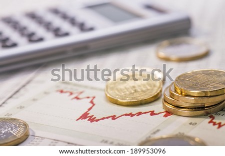 Coins, chart and calculator as a symbol for exchange rates. Royalty-Free Stock Photo #189953096