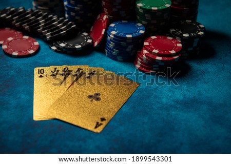 Casino. Poker. Game chips lie on the table against a blue background. Game chips for betting in gambling. Poker chips. Playing cards.