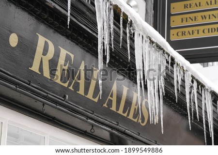 Icicles hang from ledge of Public House in winter in the UK