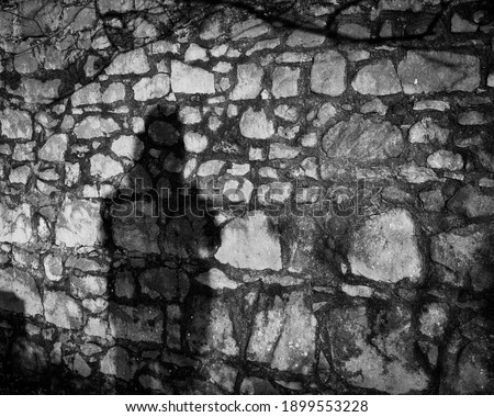 Man's shaddow on old stone wall