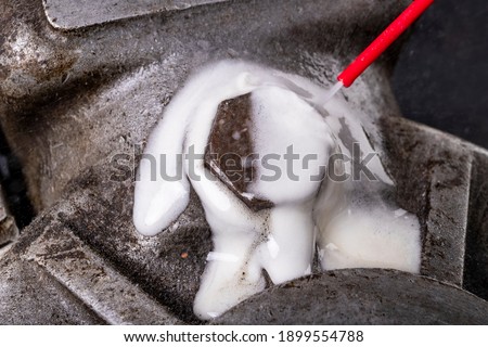 Removing a seized and rusty screw with a chemical agent. Minor repair work on the internal combustion engine. Workshop workplace. Royalty-Free Stock Photo #1899554788