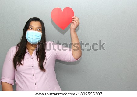 
latin woman with protection mask clinical use and red heart, valentine in contingency covid-19
