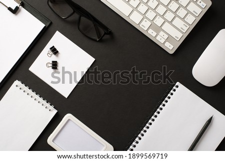 Top flat lay overhead above view photo of office supplies items objects computer wireless mouse paper copybooks eyeglasses with empty blank space for design text isolated black backdrop