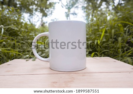 Mug mockup, white mug on wood with a natural landscape of an orange plantation. Great for layering your custom quotes and designs for selling mugs.