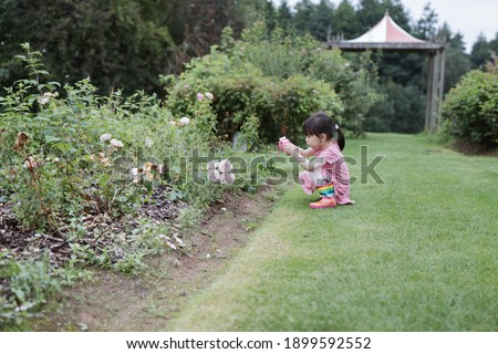young girl taking photo in the summer garden morning 