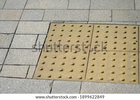 The boundary between the Braille block and the ground