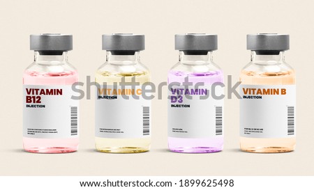 Vitamin injection glass bottles on beige background Royalty-Free Stock Photo #1899625498