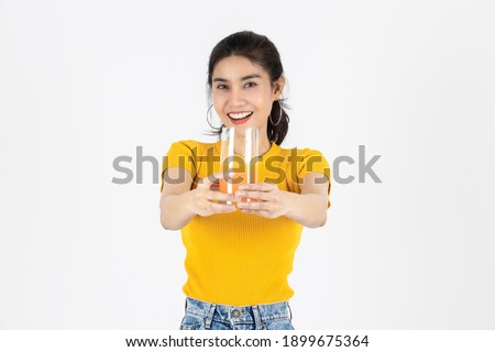 Beauty young Asian woman showing glass of orange juice over white isolated background. Lifestyle, Diet, Healthy and clean food concept.