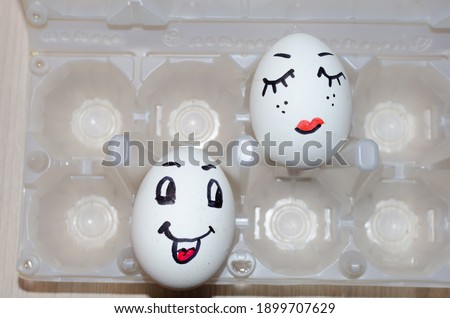 Funny eggs with painted face in the box.