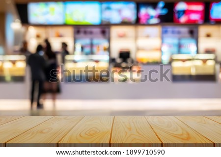 Empty wooden table background of free space for your with defocused food bar movie theater, for your product display