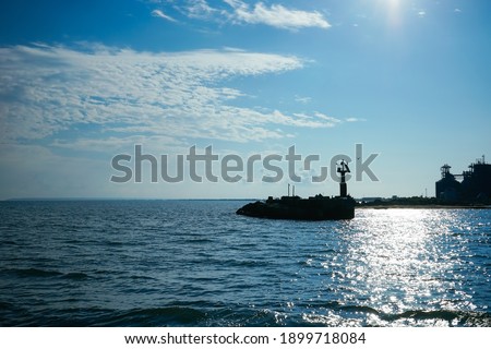 Seascape with a silhouette of a lighthouse and a coastline. Kerch, Crimea