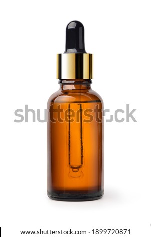 Essential serum oil in amber dropper bottle with gold cap isolate on white background. Clipping path. Royalty-Free Stock Photo #1899720871